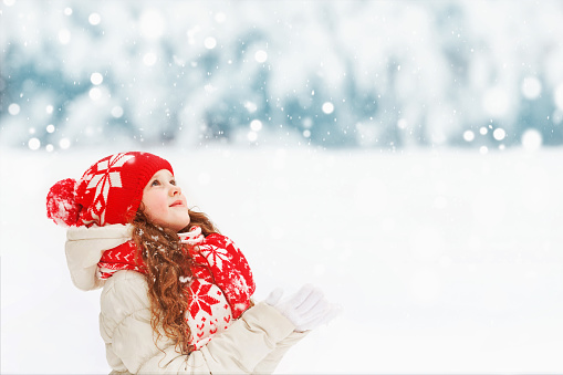 Teenage girl enjoying the the winter and the snow. The girl is jumping in the air and throwing the snow up.\nShot with Canon R5