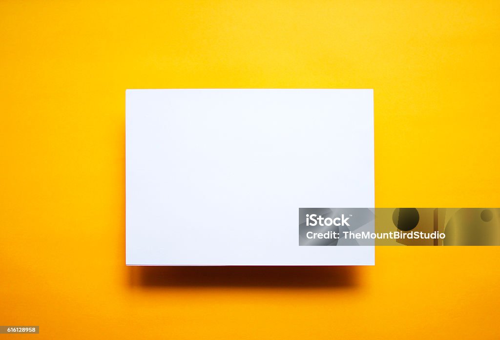 Empty white paper sheet isolated yellow background Empty white paper sheet isolated on yellow background Template Stock Photo