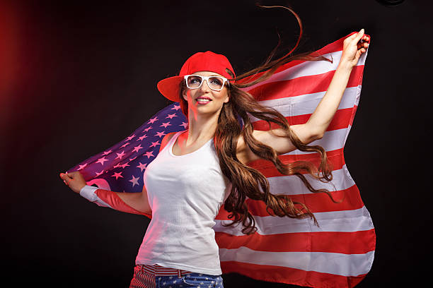 Girl in a baseball cap holding a US flag