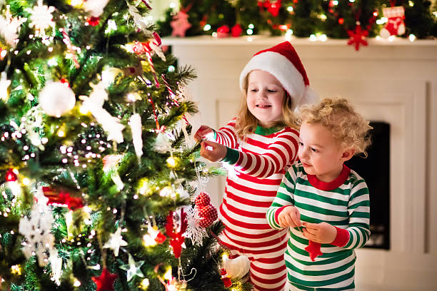 istock Kids in pajamas decorate Christmas tree 616131704
