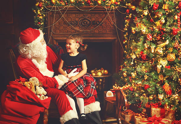 istock happy child girl hugging Santa 616131948
