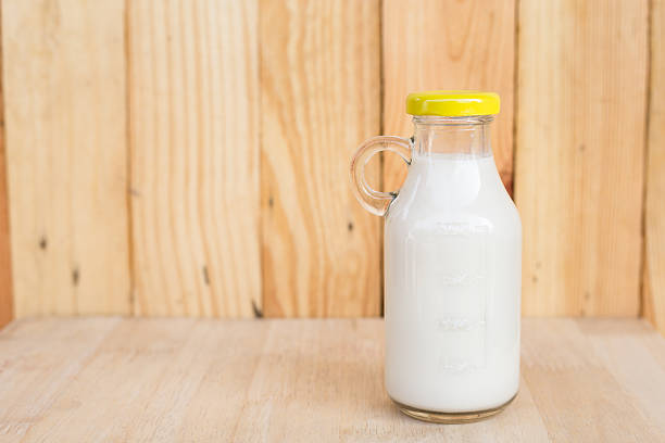 istock Bottle of fresh milk on wooden table. 616132462