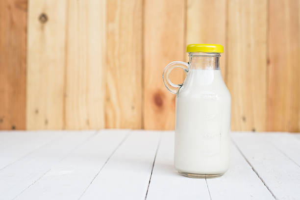 istock Bottle of fresh milk on wooden table. 616132470