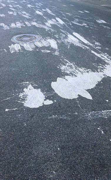 istock dark asphalt with big spots of spilt white paint 616132818