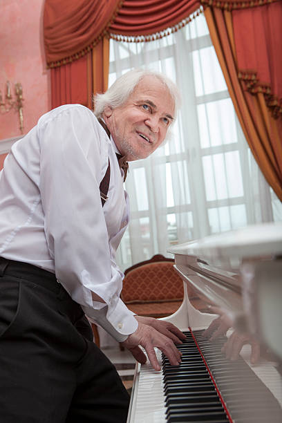 istock Mature musician playing a white piano 616133000