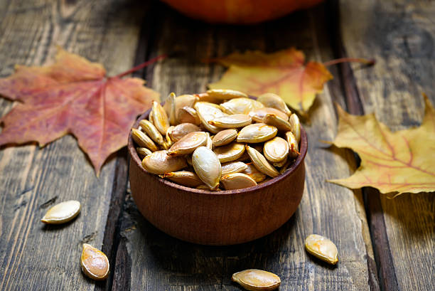 istock Pumpkin seeds and autumn maple leaves 616135250