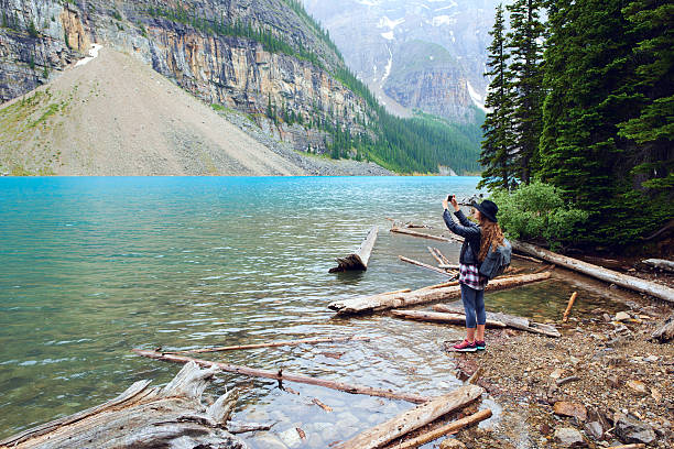 istock Young beautiful female backpacker doing pictures on her phone 616220540