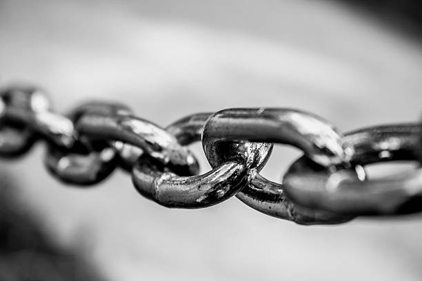 Chained Closeup shot to a stretched chain. Shot made in black and white anchor chain stock pictures, royalty-free photos & images