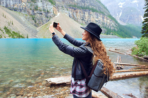 istock Young beautiful female backpacker doing pictures on her phone 616221194