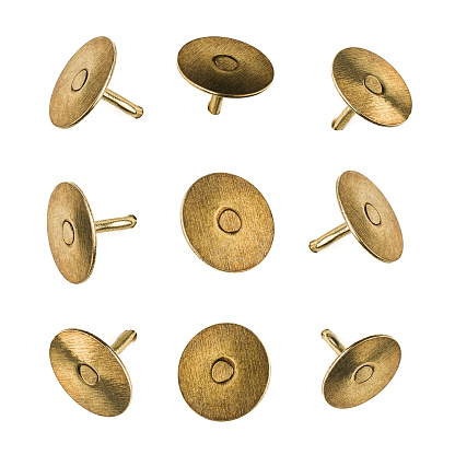 Product photograph, closeup or macro of a set of metal pushpins isolated on white seamless background