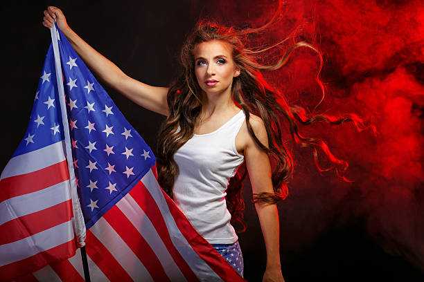 istock Girl holding US flag on a flagpole 616228034