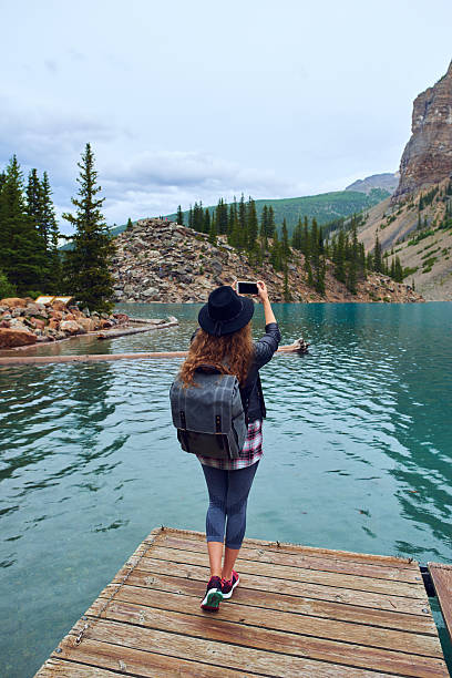 istock Young beautiful female backpacker doing pictures on her phone 616229678