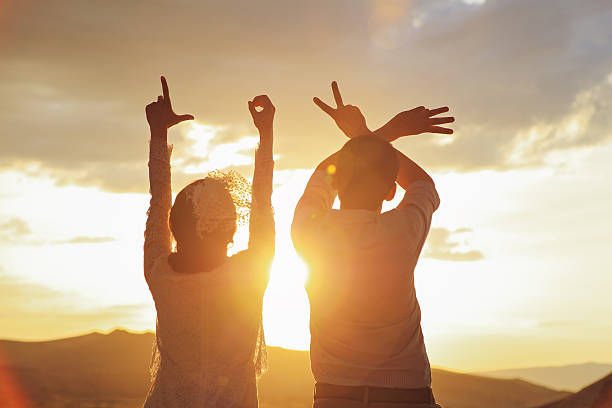 istock Newlyweds making heart sign 616230272