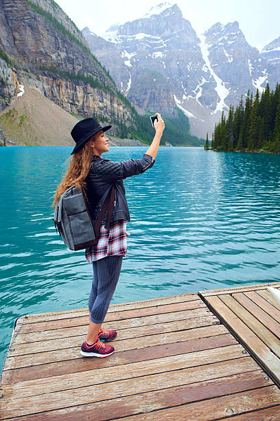 istock Young beautiful female backpacker doing pictures on her phone 616230310