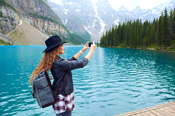 istock Young beautiful female backpacker doing pictures on her phone 616232062