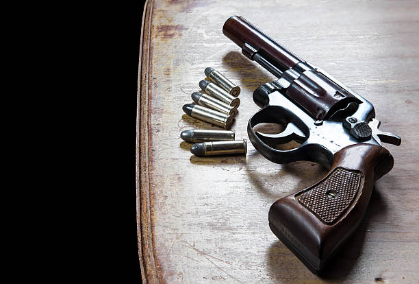 istock Old hand gun and bullets on wooden background 616243368
