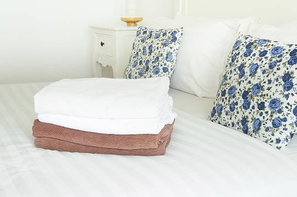 istock White and brown towels on clean bed with double pillows 616248302
