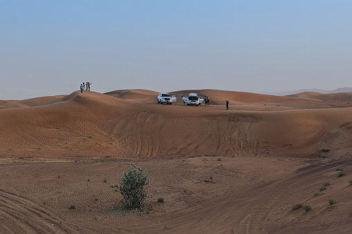 Car on sand dunes in the desert, Merzouga, Erg Chebbi sand dunes region, Sahara, Morocco.