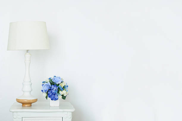 istock Vintage lamp and artificial bouquet on white small desk, 616248474