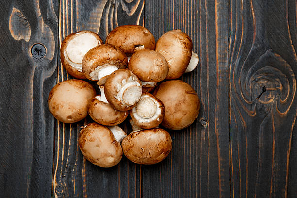 istock champignon mushroom on wooden background 616255196