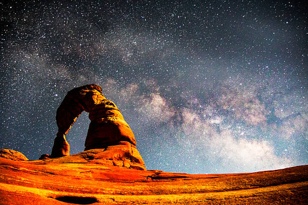 la voie lactée au-dessus de delicate arch, parc national des arches - natural arch photos et images de collection