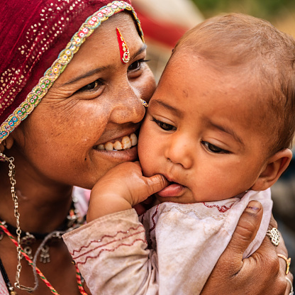 Young Indian mother holding her little baby - desert village, near Jodhpur, Rajasthan, India.