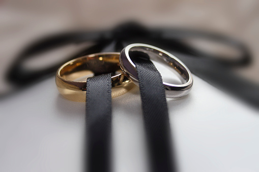Two wedding rings male and female linked by ribbon