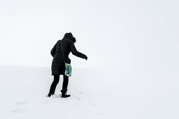 istock Woman walking in a snowy field 616263702