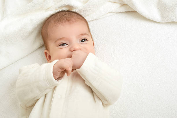 istock baby on white towel in bed 616854580