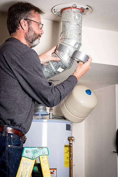 istock Plumber applies tape on duct work 616862406