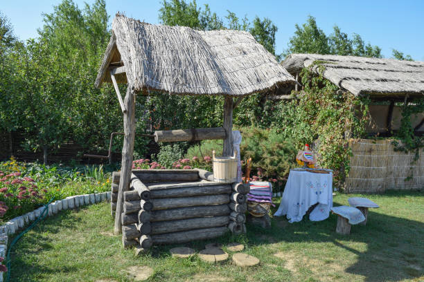 Well with a thatched roof Well with a thatched roof. Wooden housing village well. tie game stock pictures, royalty-free photos & images