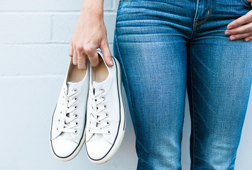 Woman posing in jeans and converse shoes.