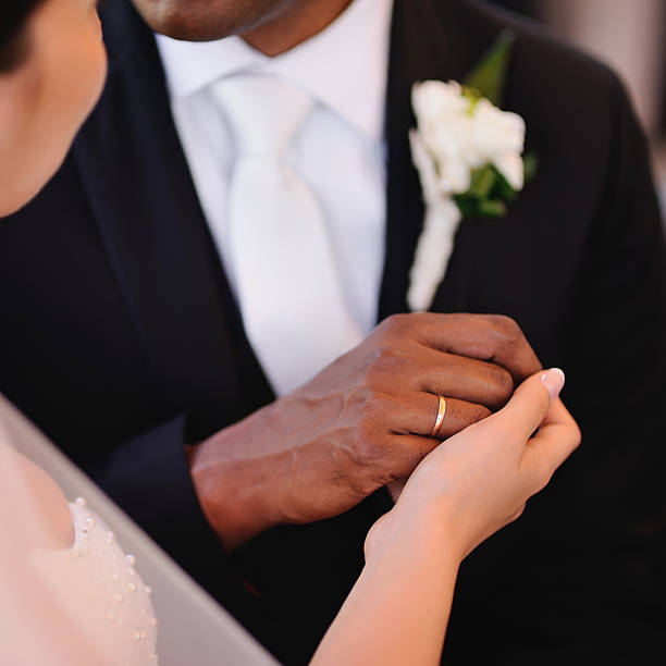 istock bride and groom holding hands 616867126
