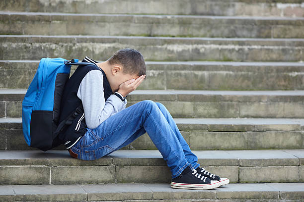 istock schoolboy crying on the street 616867502