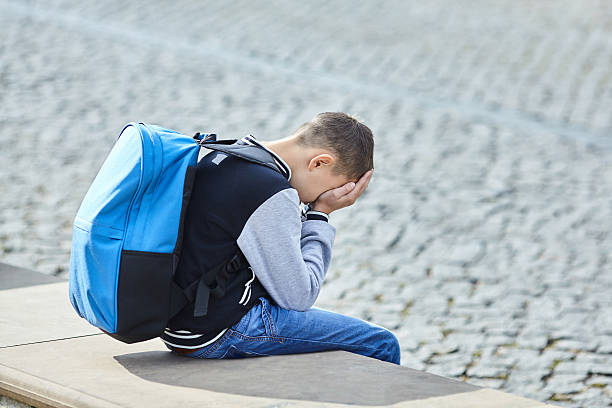 istock schoolboy crying on the street 616867702
