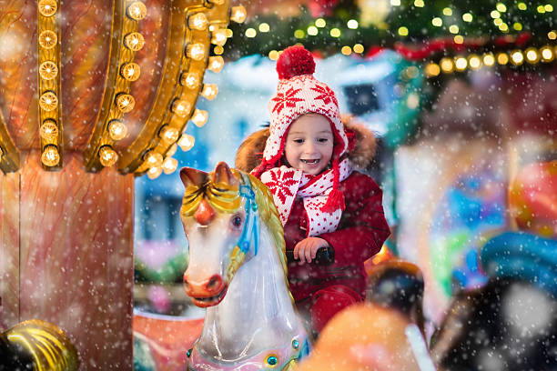 istock Child riding carousel on Christmas market 616868276