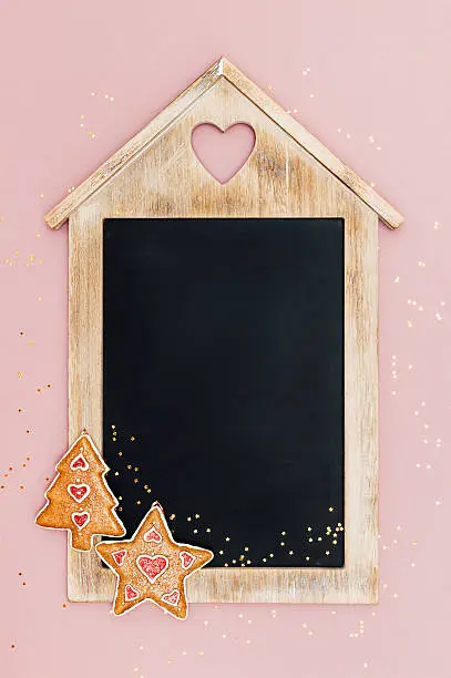Christmas chalkboard, with star and christmas tree decorations and golden star-shaped glitter. Vintage style. Top view. With space for text.