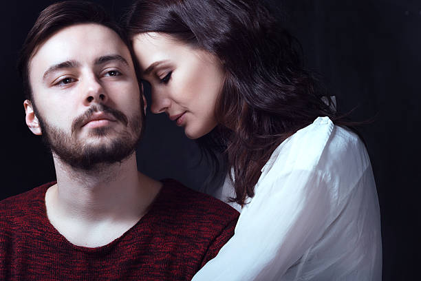 istock Beautiful cute loving couple in a studio with dark walls 616869220