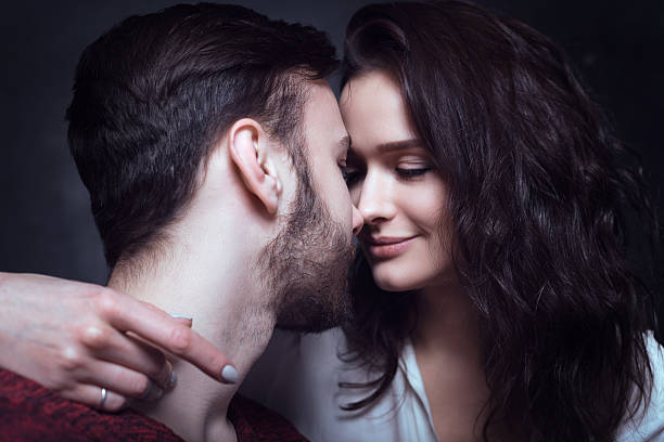 istock Beautiful cute loving couple in a studio with dark walls 616869802