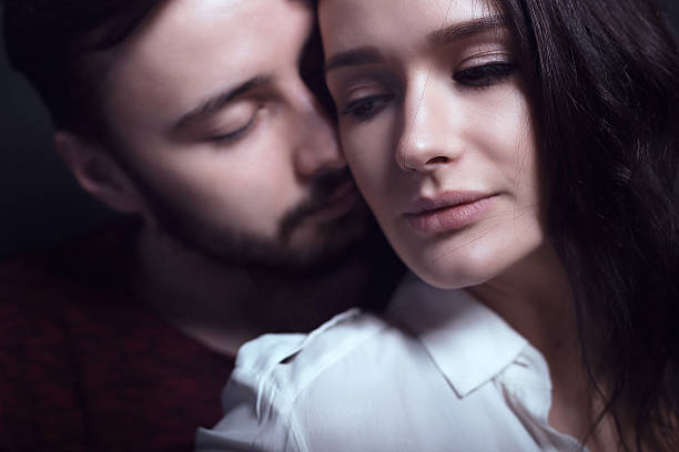 istock Beautiful cute loving couple in a studio with dark walls 616870340