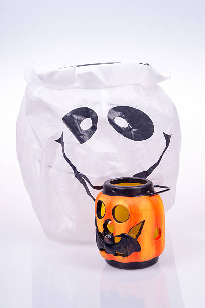 istock ghosts and halloween pumpkins in the foreground on white background 616871834