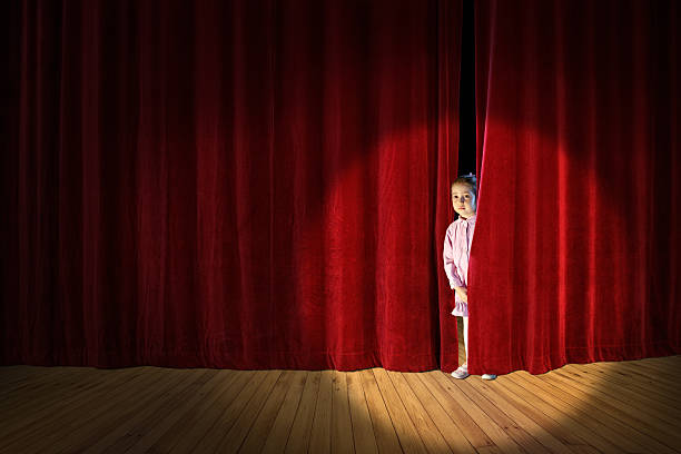 istock shy little girl on stage 616874820