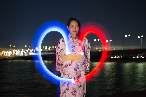 Young yukata woman standing in front of river