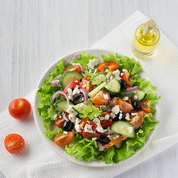 istock Fresh vegetable Greek salad with oil bottle, top view 616877052