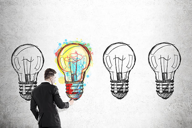 istock Businessman coloring one of four bulbs 616877156