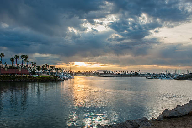 istock Dawn clouds break for sun on marina. 616877938