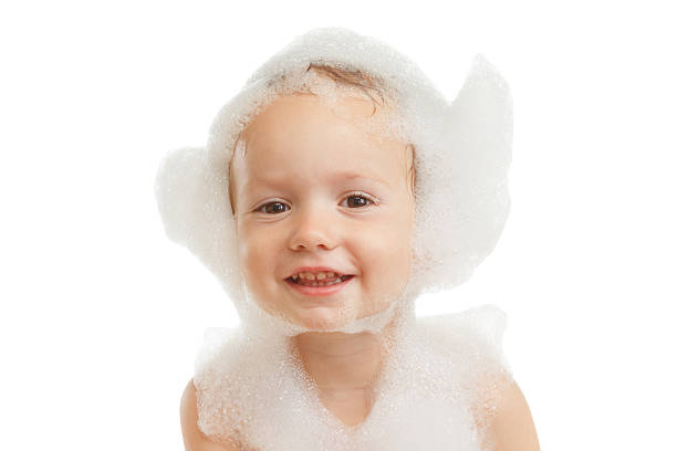 Baby boy with soap foam or shampoo on his head