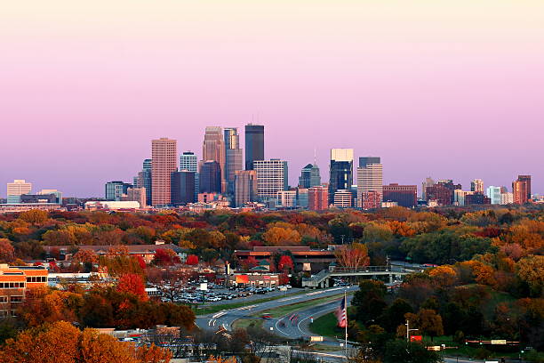 Minneapolis Skyline during Autumn at Sunset from Plymouth, Minnesota A view of the Minneapolis skyline during the peak of color in the Fall from Plymouth, Minnesota.  This image was captured right at sunset.  The city of Golden Valley and highway 55 appear in the foreground. minneapolis stock pictures, royalty-free photos & images