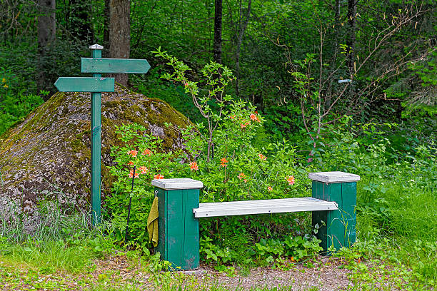 Park wooden bench with hand towel and pointers in Mustila Arboretum, Finland