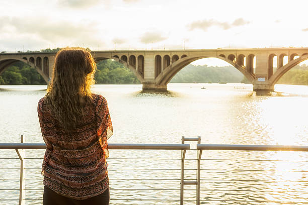 istock Back of young woman looking over potomac river 616880840
